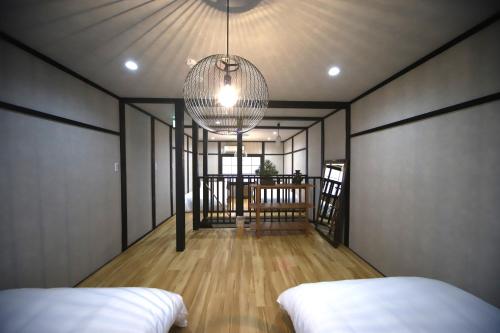 a room with two beds and a chandelier at 宿ZEN in Nishi-kujō-Toriiguchichō