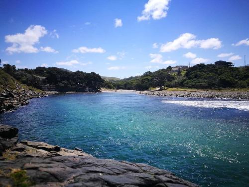 a large body of water with a rocky shore at CORAM DEO SaltyWaves double en-suite rooms with sea views in Coffee Bay