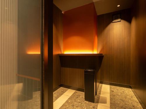 a bathroom with a sink and a wall with lights at Loisir Hotel Kyoto Toji in Kyoto