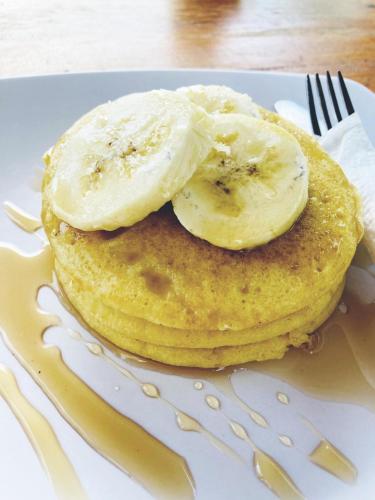 a stack of pancakes with bananas on a plate at Poling sea view in Batununggul