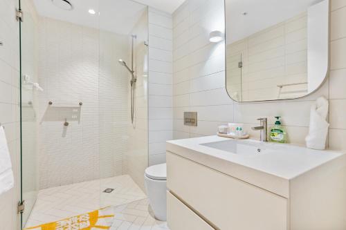 y baño blanco con lavabo y ducha. en St Kilda Road 2 Bedrooms Apartment * swimming Pool, en Melbourne