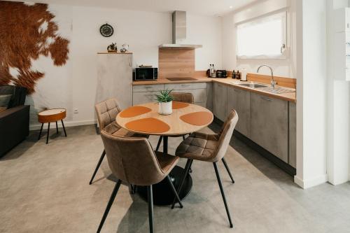 a kitchen with a table and chairs and a sink at Les Gîtes de l'Altévic in Hattstatt