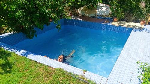 a woman is swimming in a swimming pool at Dar assounfou in Demnat
