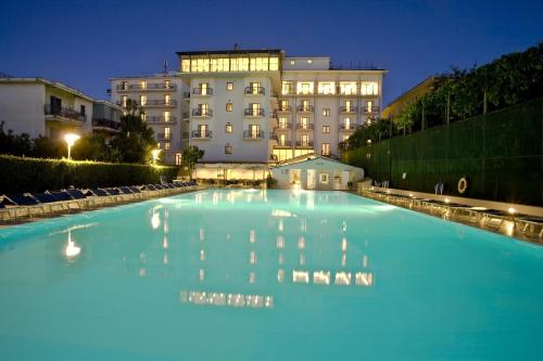 una gran piscina de agua azul frente a un edificio en Grand Hotel Flora en Sorrento