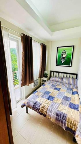 a bedroom with a bed and a window at MM’s Place at Woodhills Tagaytay in Tagaytay