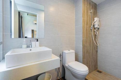 ein Badezimmer mit einem Waschbecken, einem WC und einem Spiegel in der Unterkunft Arte Plus Ampang KLCC View in Kuala Lumpur