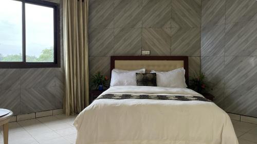 a bedroom with a large bed with white sheets and pillows at Hotel les Polygones Kribi in Kribi