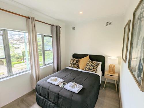 a bedroom with a bed with two towels on it at Lotus Stay Manly - Apartment 29E in Sydney