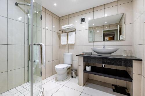 y baño con lavabo, aseo y ducha. en African Sky Newcastle Inn en Newcastle