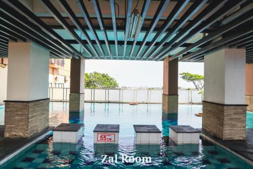 een zwembad in een gebouw met water bij AzzaRoom panoramic in Bandung