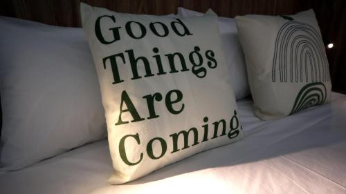 a pillow that says good things are coming on a bed at 日日旅樹 Green Stay in Hualien City