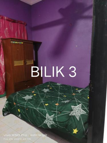 een slaapkamer met een bed met een groen dekbed bij D’sireh homestay in Sik