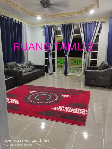 een woonkamer met banken en een rood tapijt bij D’sireh homestay in Sik