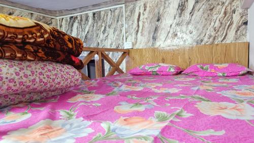 a bedroom with a pink bed with pillows on it at Tea corner Guest house in Darjeeling