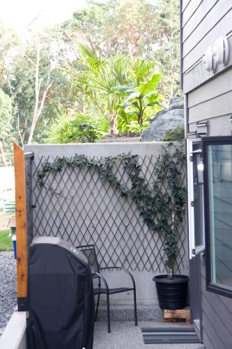 a patio with two chairs and a fence at M&M's Maple Bay Mountain Guesthouse in Duncan