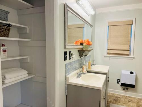 a white bathroom with a sink and a mirror at Mountain Lake Retreat - hot tub, lake, fire pit, wineries, restaurant in Harpers Ferry