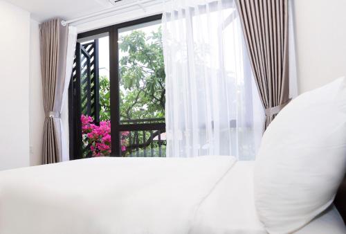 a bedroom with a white bed and a window at Wins Apartment in Hanoi