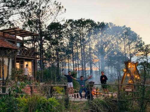 a group of people standing in front of a forest at Romantic house on a pine hill Dalat in Xuan An