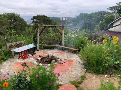 a garden with a bench and a table and flowers at Romantic house on a pine hill Dalat in Xuan An