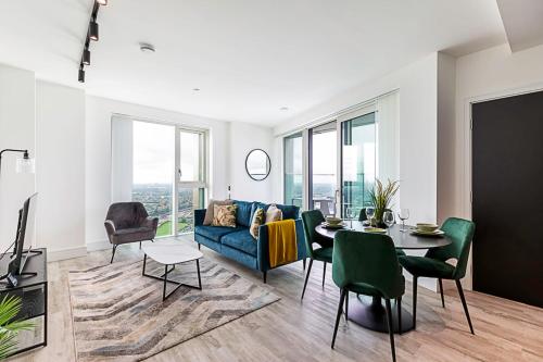 a living room with a blue couch and a table at Modern Sky-High Flat In North Acton in London