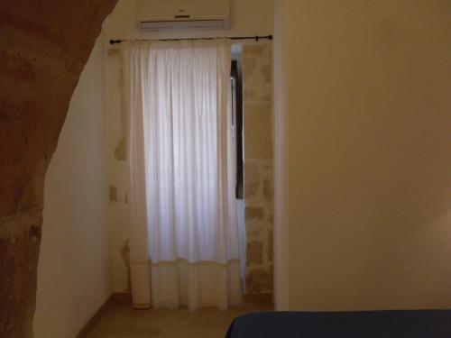 a room with a window with a white curtain at Casa Giacchino in Noto