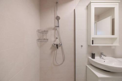 ein weißes Bad mit einer Dusche und einem Waschbecken in der Unterkunft NEW! Convenient ViennaLove Apartment WienMeidling in Wien