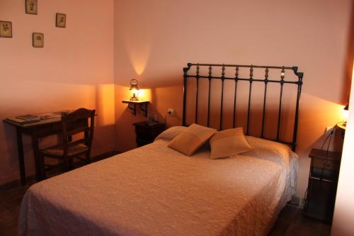 a bedroom with a bed with two pillows and a desk at Mesa del Conde in San Felices de los Gallegos