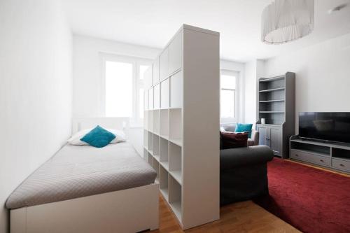 ein Schlafzimmer mit einem Bett, einem Sofa und einem TV in der Unterkunft NEW! Convenient ViennaLove Apartment WienMeidling in Wien