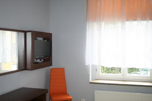 トルンにあるHotelik w Centrumのテレビ、窓が備わる客室です。