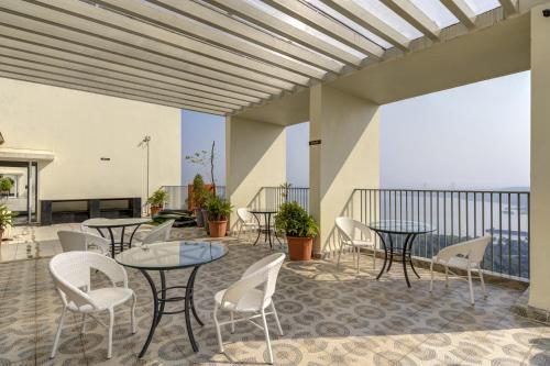 a patio with tables and chairs on a balcony at 10 min to GOI Airport & Baina Beach - Swimming Pool in Dabolim