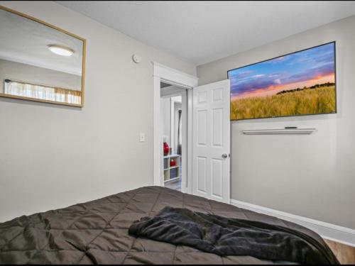 a bedroom with a bed and a large painting on the wall at St Paul Fry Street Den Suite#1 in Saint Paul