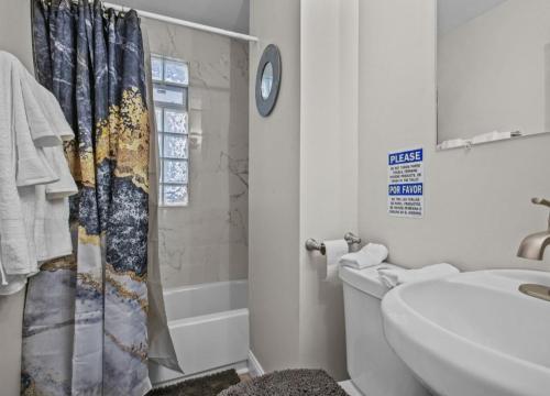 a bathroom with a toilet and a shower curtain at St Paul Fry Street Den Suite#1 in Saint Paul