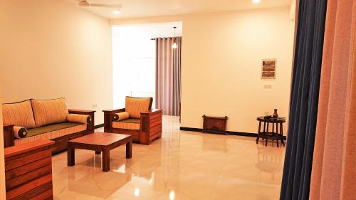 a living room with two couches and a table at Tropical Inn in Mirissa