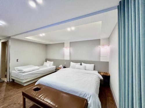 a hotel room with two beds and a couch at Series hotel in Gyeongju