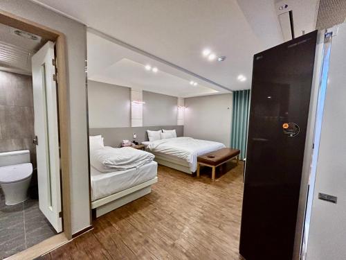 a hotel room with two beds and a toilet at Series hotel in Gyeongju