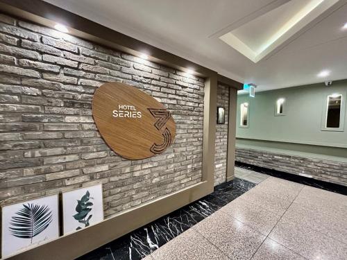 a lobby with a sign on a brick wall at Series hotel in Gyeongju