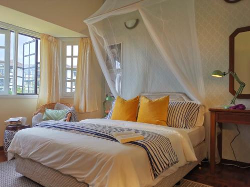 een slaapkamer met een wit bed met een hemelbed bij Green Hill Tanah Rata Cameron Highland in Tanah Rata
