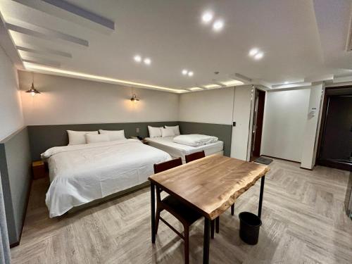 um quarto com 2 camas e uma mesa de madeira em Series hotel em Gyeongju