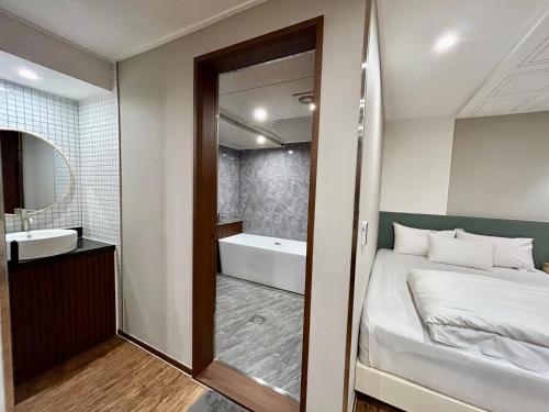a bathroom with a bed and a tub and a sink at Series hotel in Gyeongju