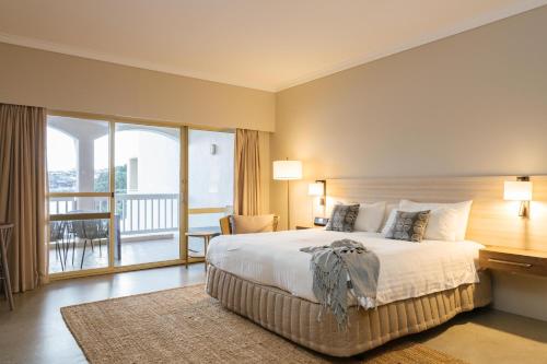 a bedroom with a large bed and a balcony at The Marina Hotel - Mindarie in Mindarie