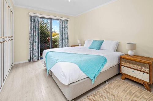 a bedroom with a large bed and a window at Sea Breeze Cottage - Convenient! in Bicheno