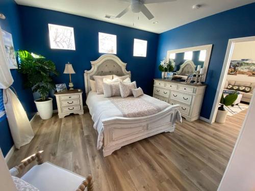 a bedroom with blue walls and a bed and a mirror at California Cottage in Tracy
