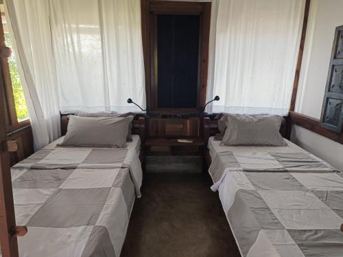 duas camas num quarto com duas janelas em Svarna em Udupi