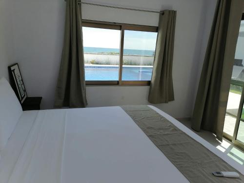 a bedroom with a large white bed and a window at V&G Las vacaciones que mereces in Ursulo Galván