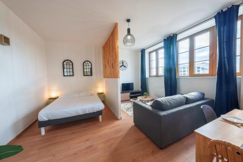 sala de estar con cama y sofá en Le Lotus - ZMN Conciergerie en Saint-Quentin