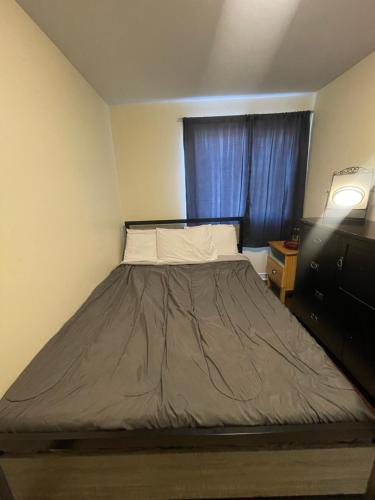 a bed in a small room with a window at Charming One Bedroom Near Bramalea City Centre in Brampton