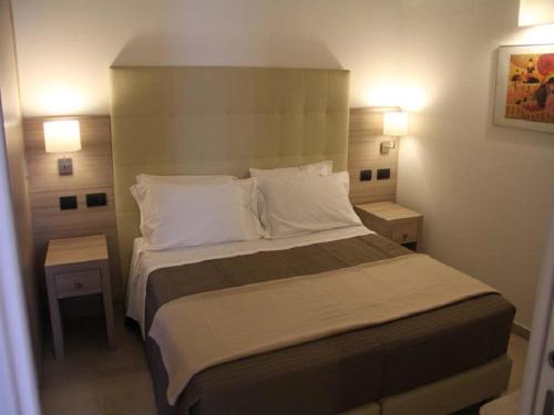 ein Schlafzimmer mit einem großen Bett mit zwei Nachttischen in der Unterkunft La Papagna Dimora Storica in Palagianello