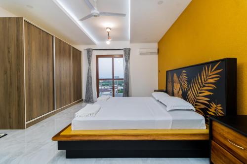 a bedroom with a large bed and a yellow wall at Aqua Penthouse Beach Apartment in Mombasa