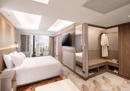 a bedroom with a white bed and a television at SAMALA Hotel Bangkok in Bangkok