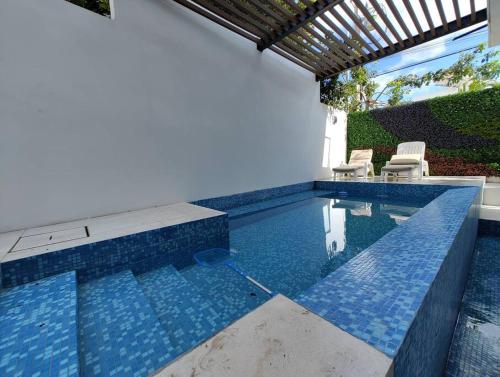 a swimming pool with two chairs and a swimming pool at El mejor Departamento en Mérida in Mérida